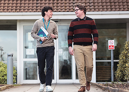 Two male CSO staff walking and chatting together in front of CSO 
